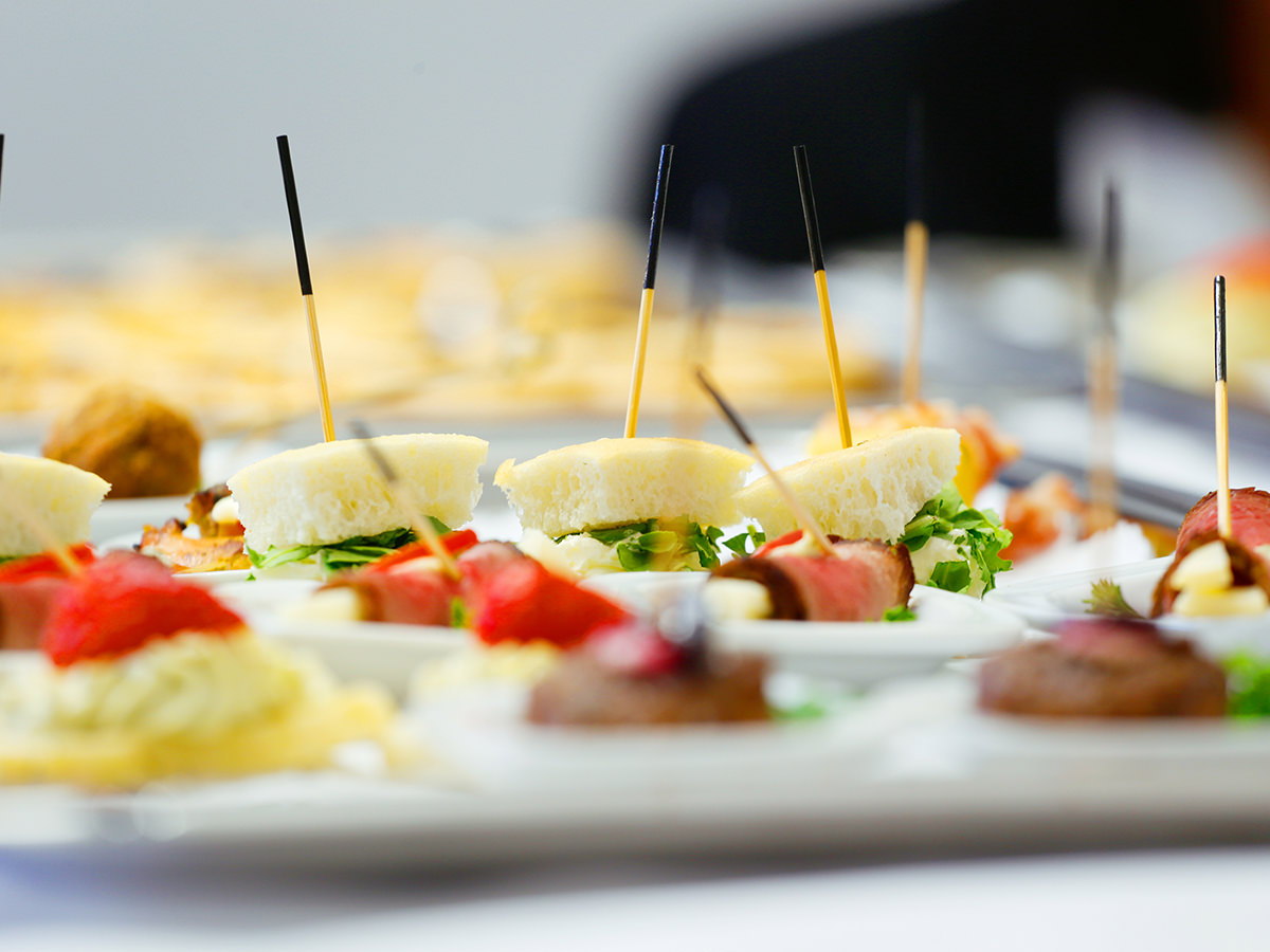 Auf einem Tablett liegen keine Appetitanreger mit Spießen. Henkelmann Gastronomiebetrieb