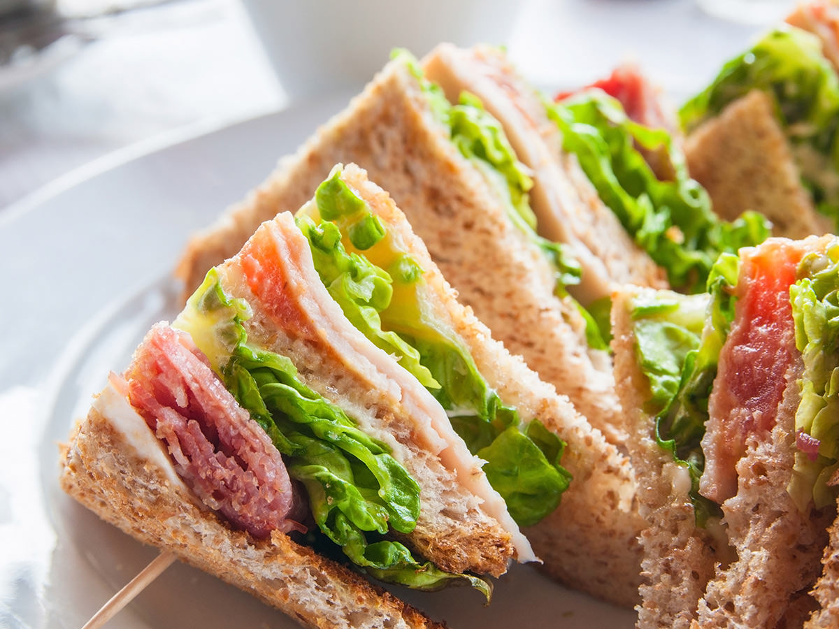 Auf einem Teller liegen Sandwiches. Henkelmann Gastronomiebetrieb