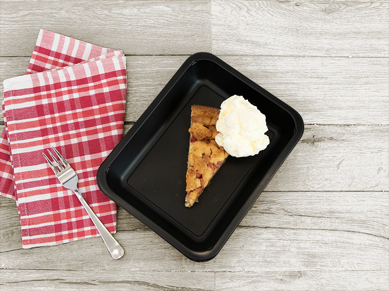 Aufwendig drapierte und frisch zubereitetes Stück Kuchen mit Sahne von Henkelmann Gastronomiebetrieb.